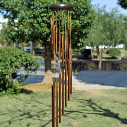 Carillon à vent bois foncé et tube or accroché à un arbre