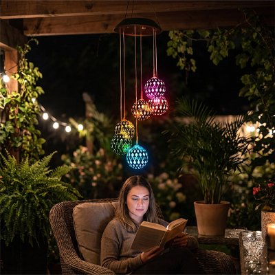 Carillon à vent lumineux illumine une femme qui lit