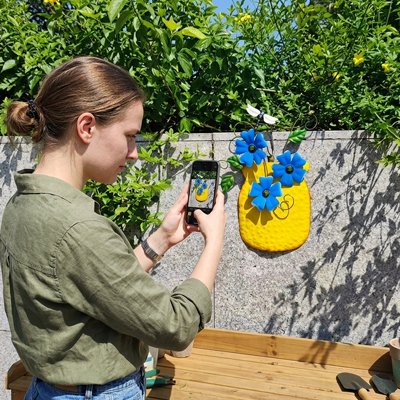 Déco mural de jardin jaune photographié par une femme
