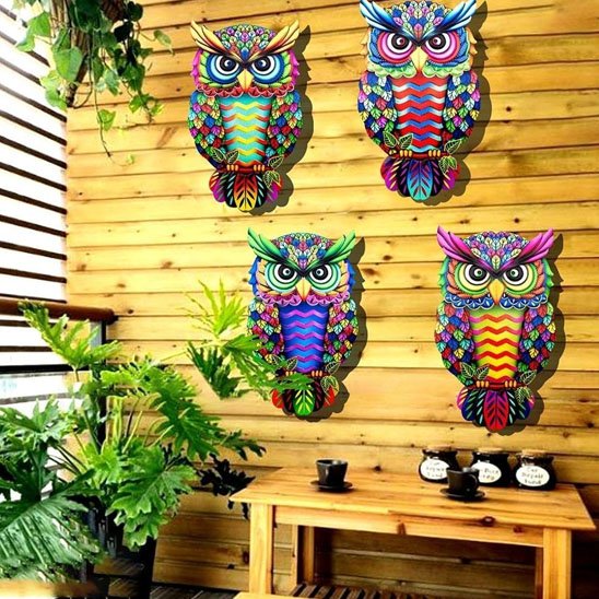 Décoration mural de jardin quate hibous colorés sur un mur de remise
