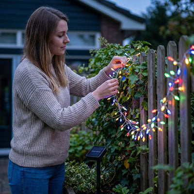 femme qui installe sa guirlande lumineuse