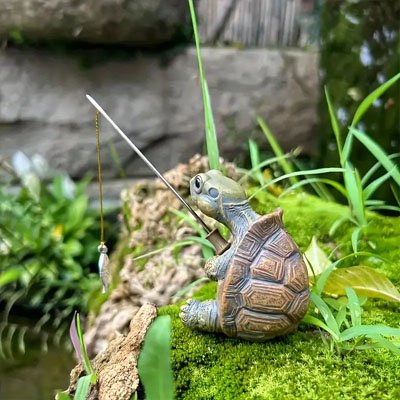 Statue de jardin tortue à la pêche sur une roche